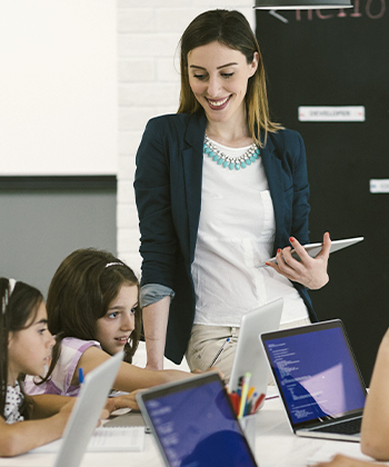 Teacher overlooking students using laptops